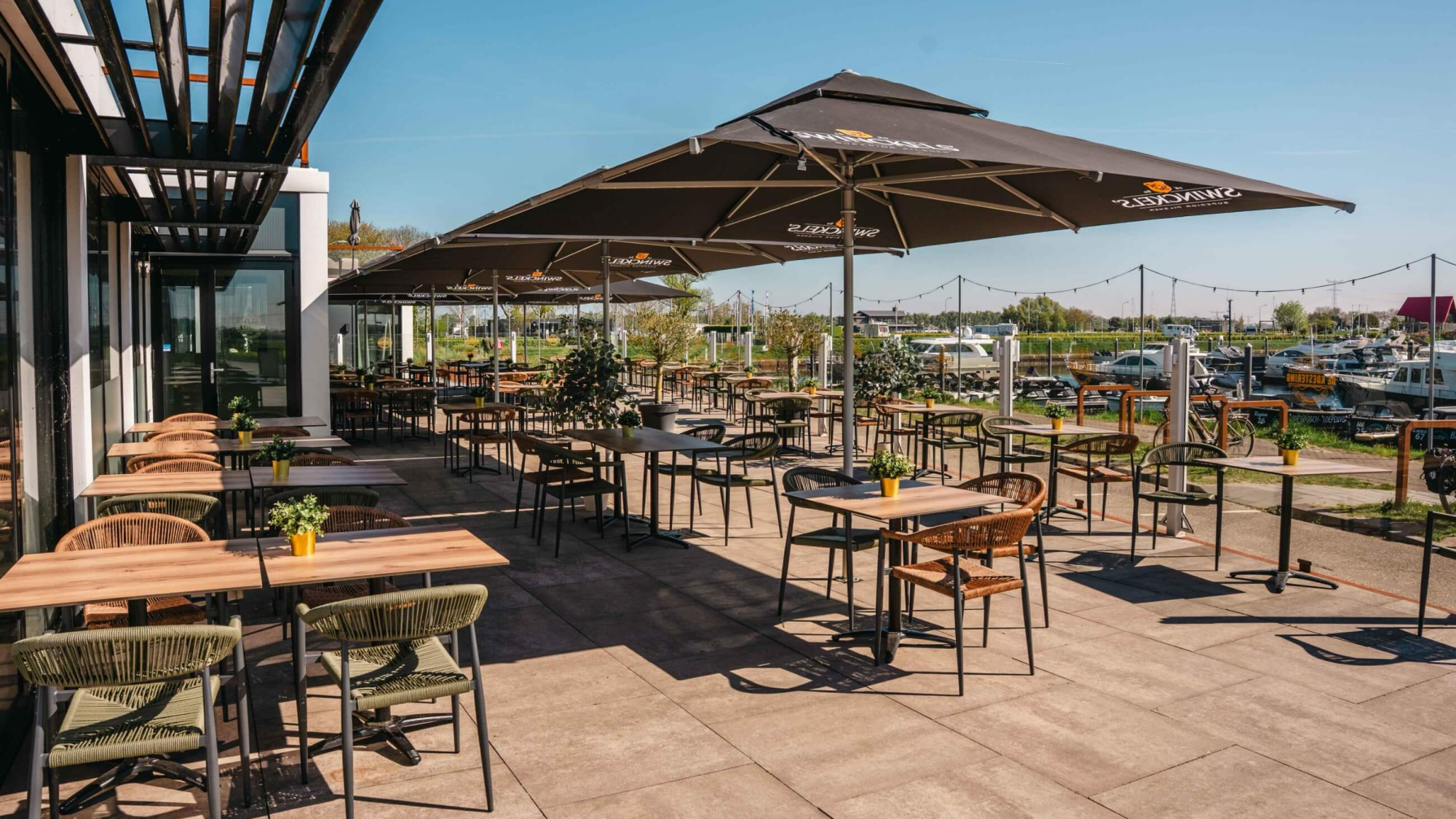 Terras in het zon aan het water bij Hotelbar De Sloep in de have